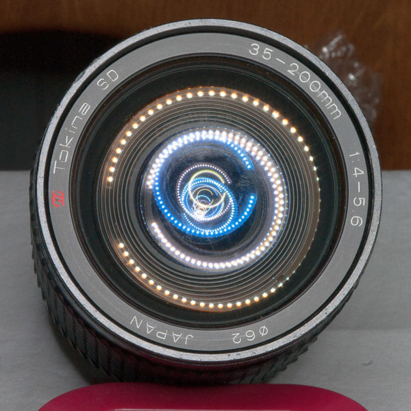 TOKINA 35-200 <br /> Altglas, leider nicht nur etwas verstaubt sondern augenscheinlich mit Glaspilz befallen. Bei der Inspektion hat das Laternenlicht der LED-Tischlampe die eingebaute Linsengruppe sichtbar gemacht. Das Objektiv habe ich danach zerlegt. Und nicht vollständig wieder zusammenbekommen. Eine winzige Kugel für den Blendenring habe ich unbedacht vom Tisch gefegt. Wenn ich die wiederfinde, versuche ich nachzrüsten. Wenn ...
