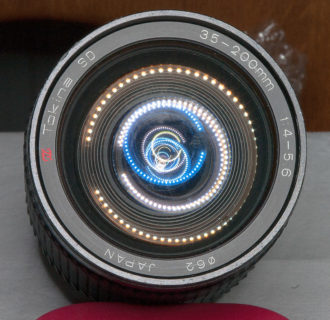 TOKINA 35-200 Altglas, leider nicht nur etwas verstaubt sondern augenscheinlich mit Glaspilz befallen. Bei der Inspektion hat das Laternenlicht der LED-Tischlampe die eingebaute Linsengruppe sichtbar gemacht. Das Objektiv habe ich danach zerlegt. Und nicht vollständig wieder zusammenbekommen. Eine winzige Kugel für den Blendenring habe ich unbedacht vom Tisch gefegt. Wenn ich die wiederfinde, versuche ich nachzrüsten. Wenn ...